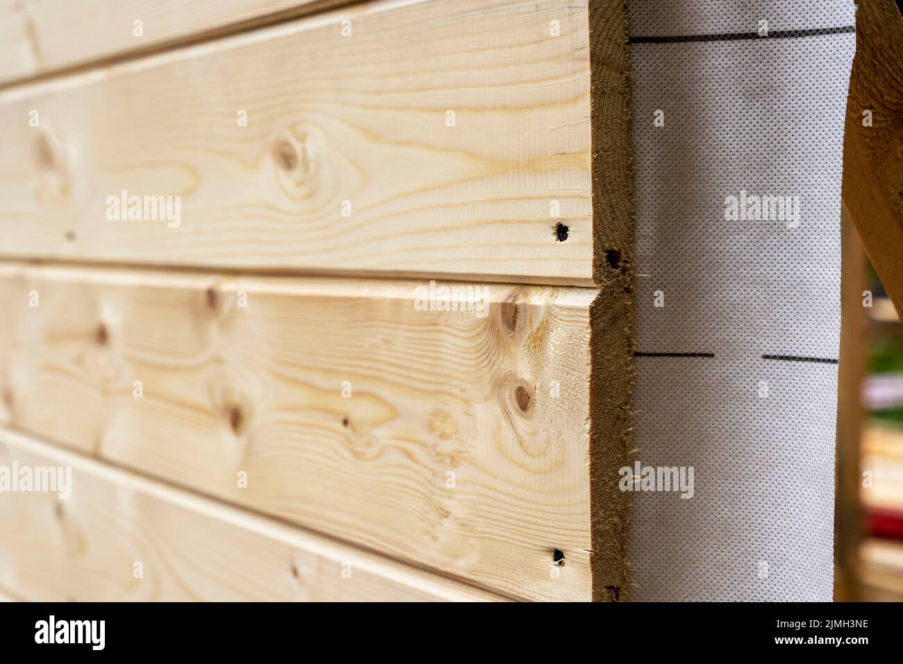 cladding of a wooden frame house with clapboard and vapor barrier