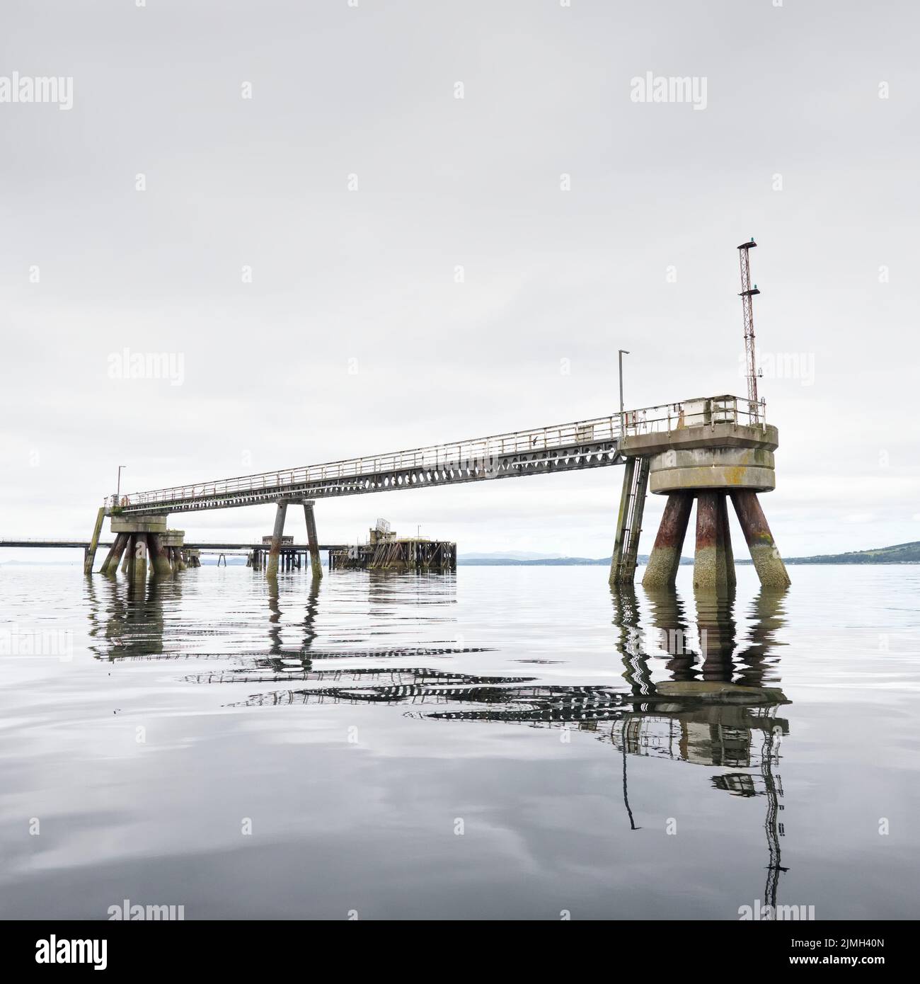 Old derelict wooden jetty pier in sea at Inverkip power station Stock Photo