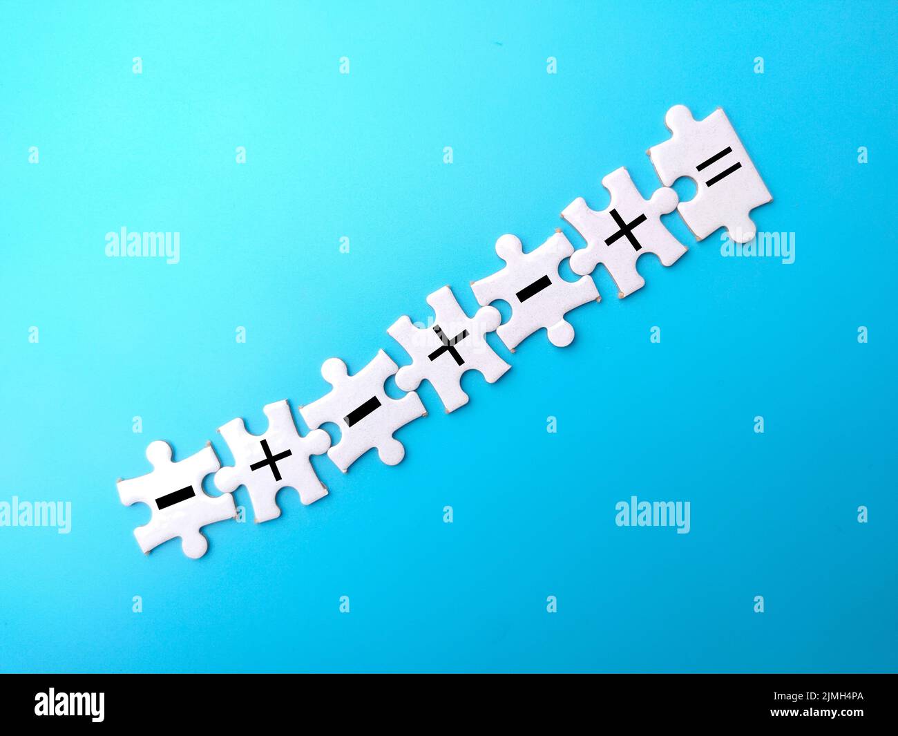 White puzzles with symbols of subtract, add and equal to on blue ...