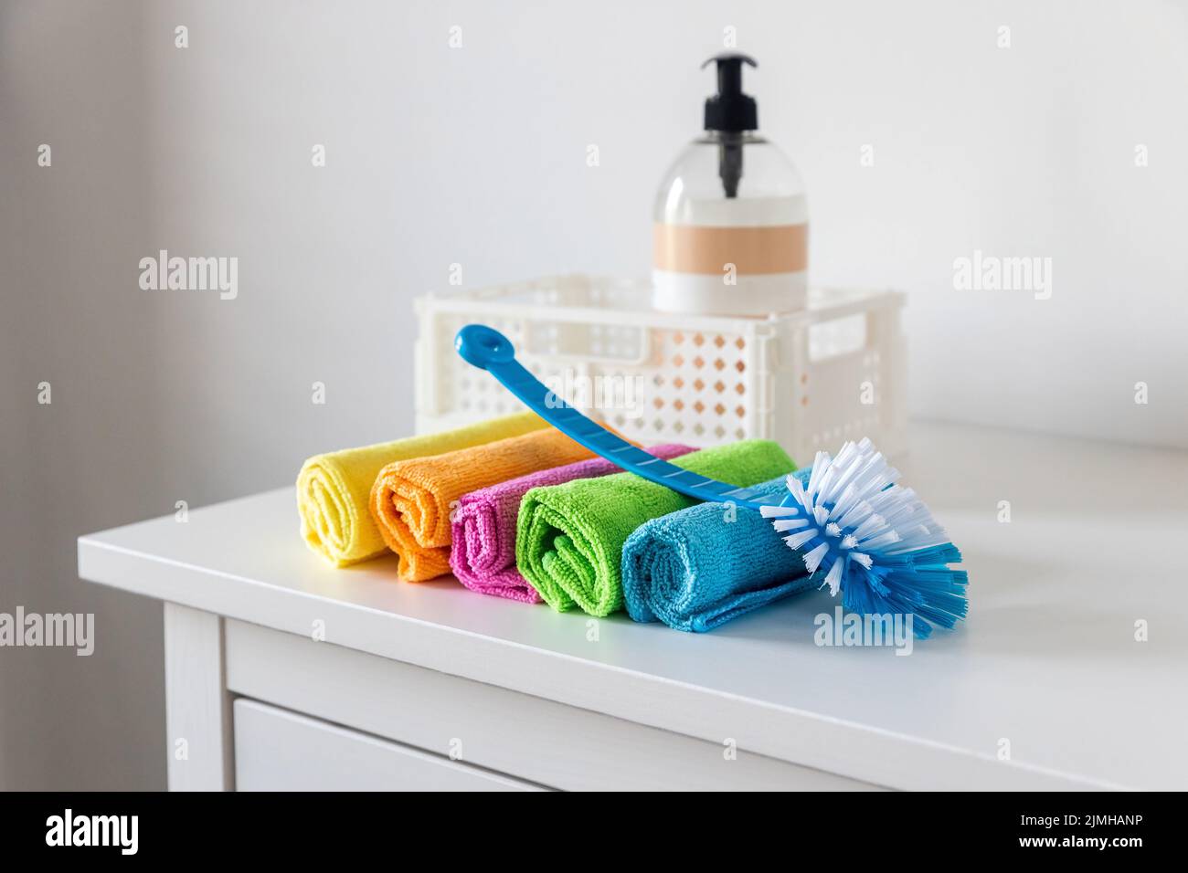 Multi-colored fiber cloths for dusting and a plastic brush Stock Photo