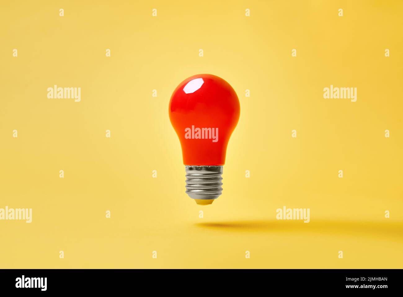 Red lightbulb levitate on yellow background. Idea, motivation concept Stock Photo