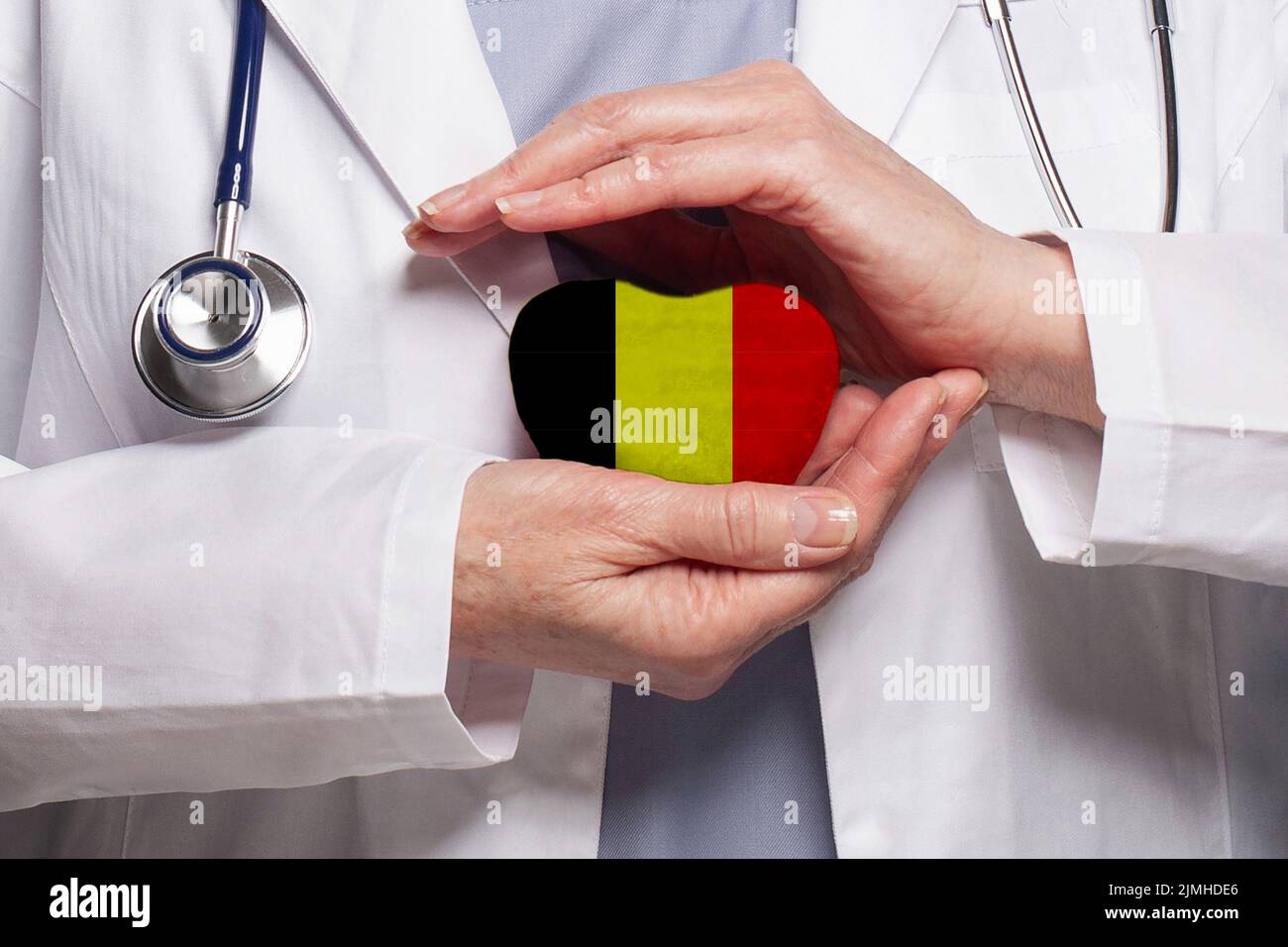 Belgian doctor holding heart with flag of Belgium background. Healthcare, charity, insurance and medicine concept Stock Photo