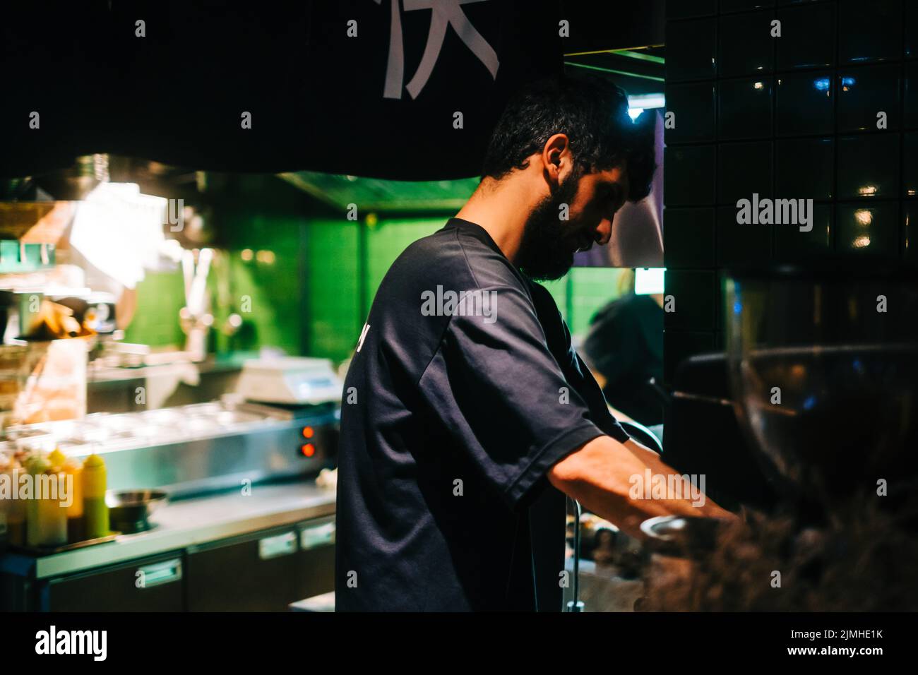 Barista man cleaning coffee machine after working day in asian cafe