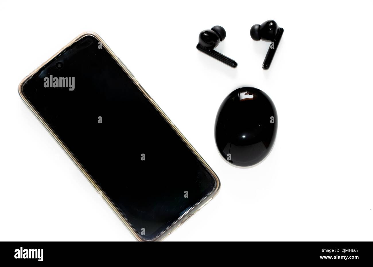 Top View Of Pair Of Black Wireless Earbuds And Smartphone In White Background Stock Photo