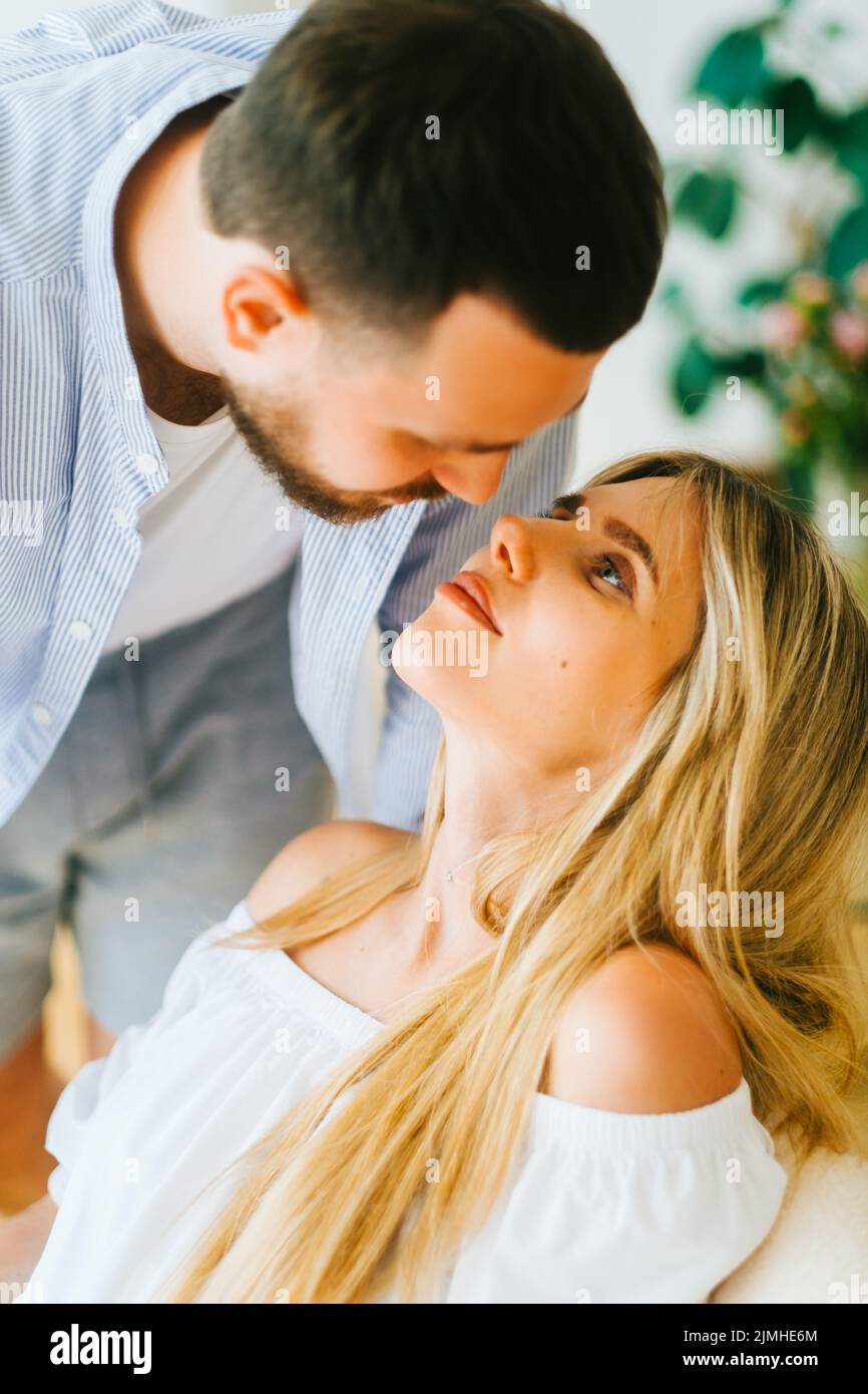 Happy young caucasian couple, husband kissing wife at home Stock Photo