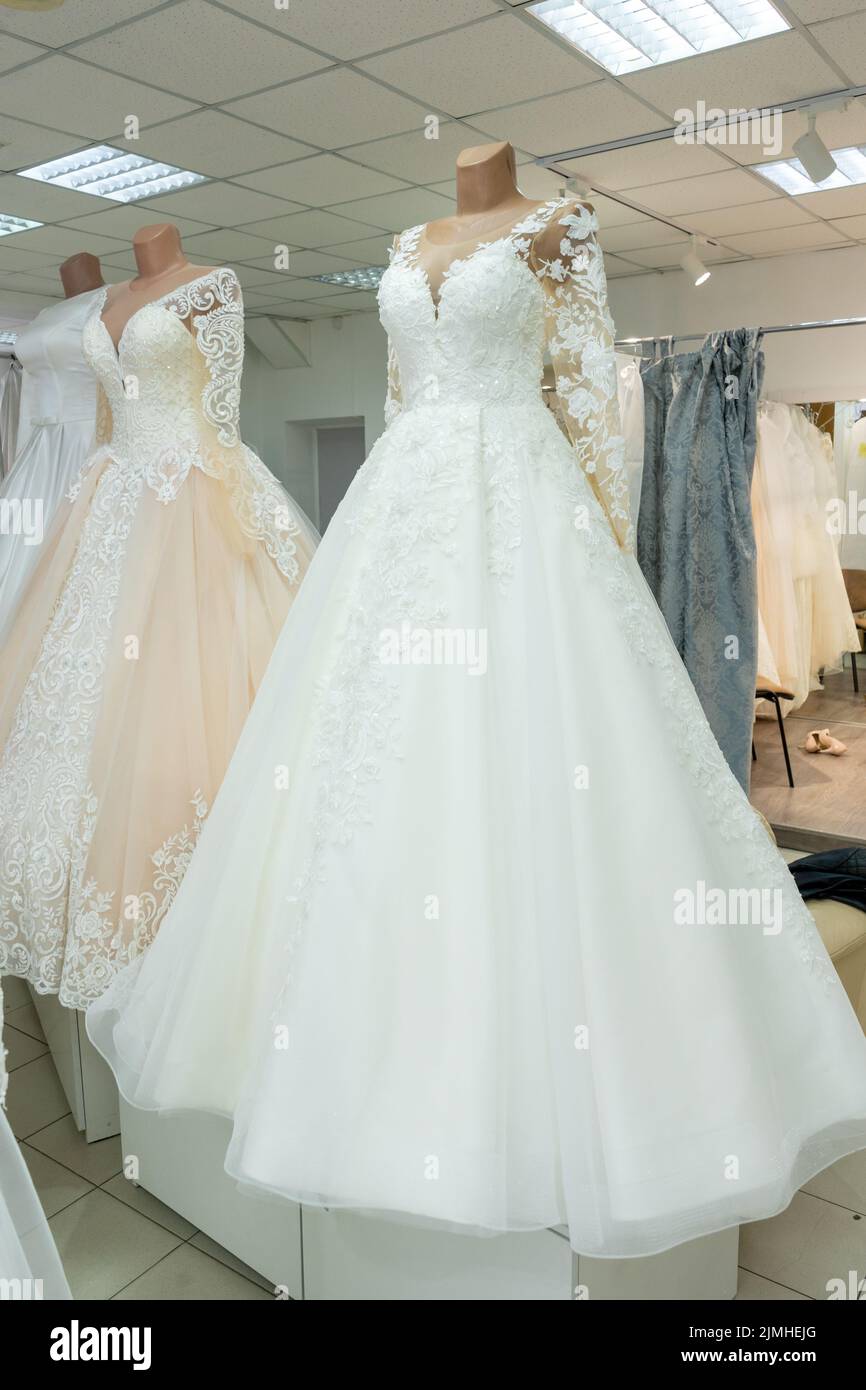 Beautiful wedding dresses in a bridal boutique on mannequins. Stock Photo