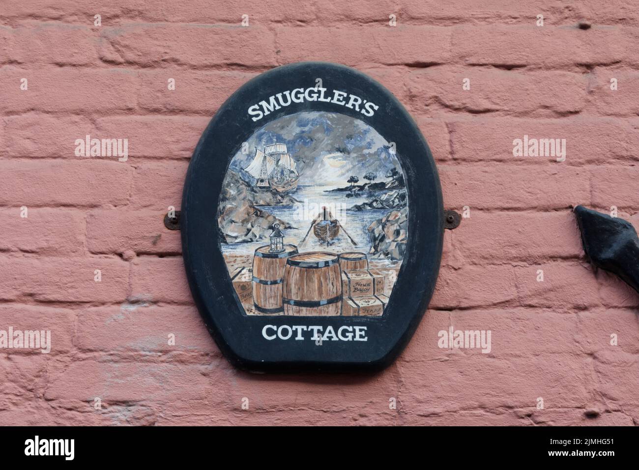 smugglers cottage sign on a pink wall Stock Photo
