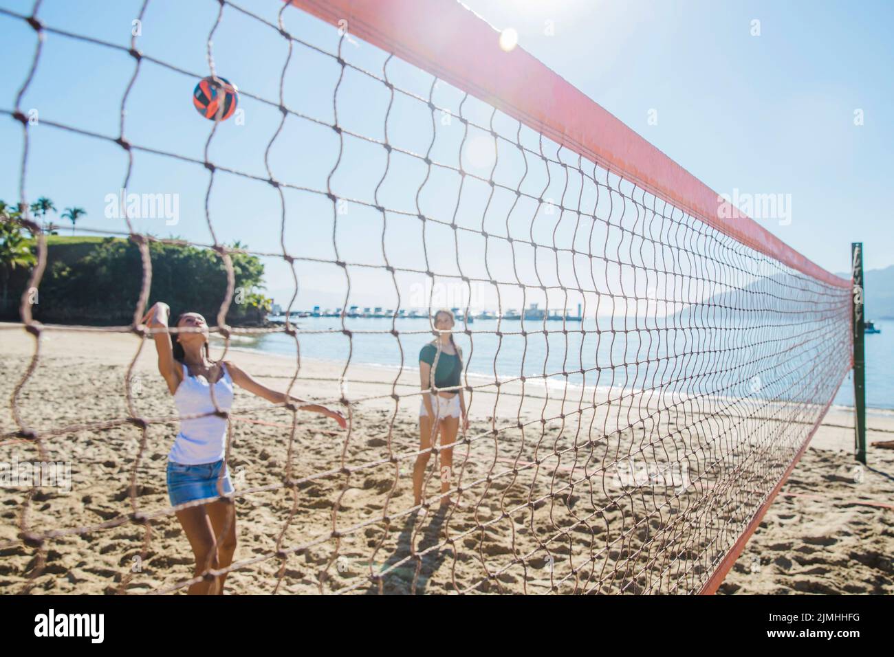 Young people playing beachvolley hires stock photography and images