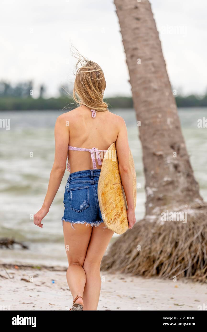 Lovely Blonde Model Enjoying A Summers Day While Preparing To Surf On The Ocean With Her Boogie Board Stock Photo