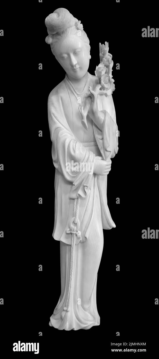 Geisha figurine in national dress, kimono traditional hair, fan in her hand. Souvenir doll, isolated on black background with cl Stock Photo