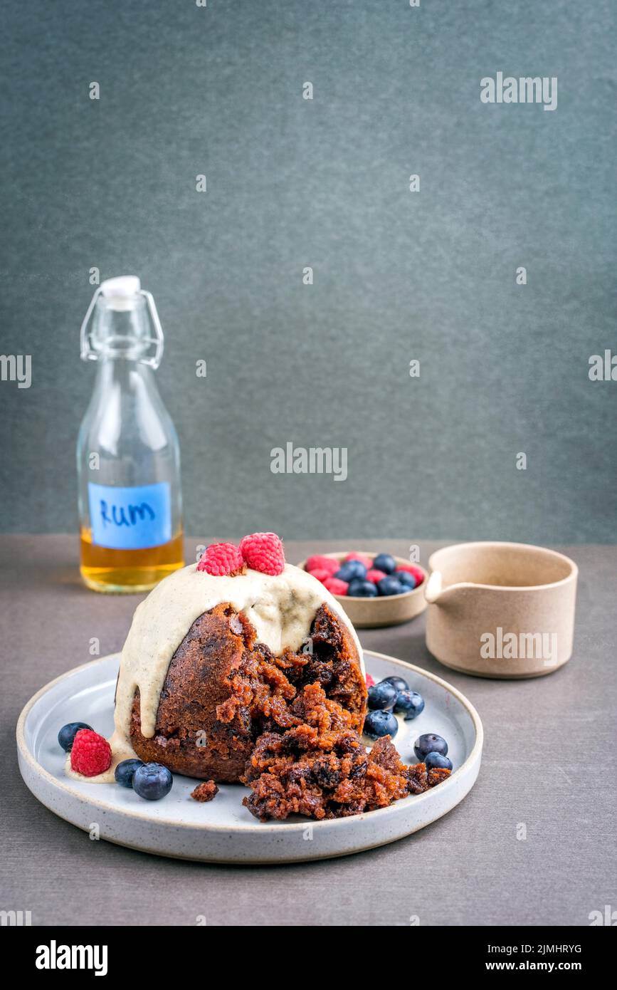 Traditional Australian plum pudding as closeup with fruits and vanilla