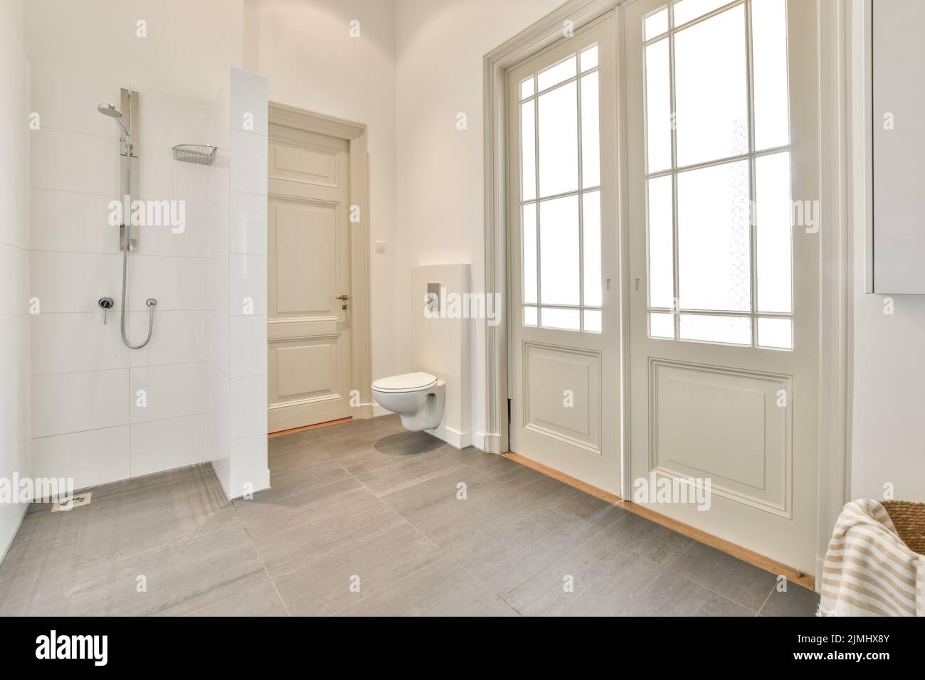 Glass partition between shower tap and wall hung toilet in modern