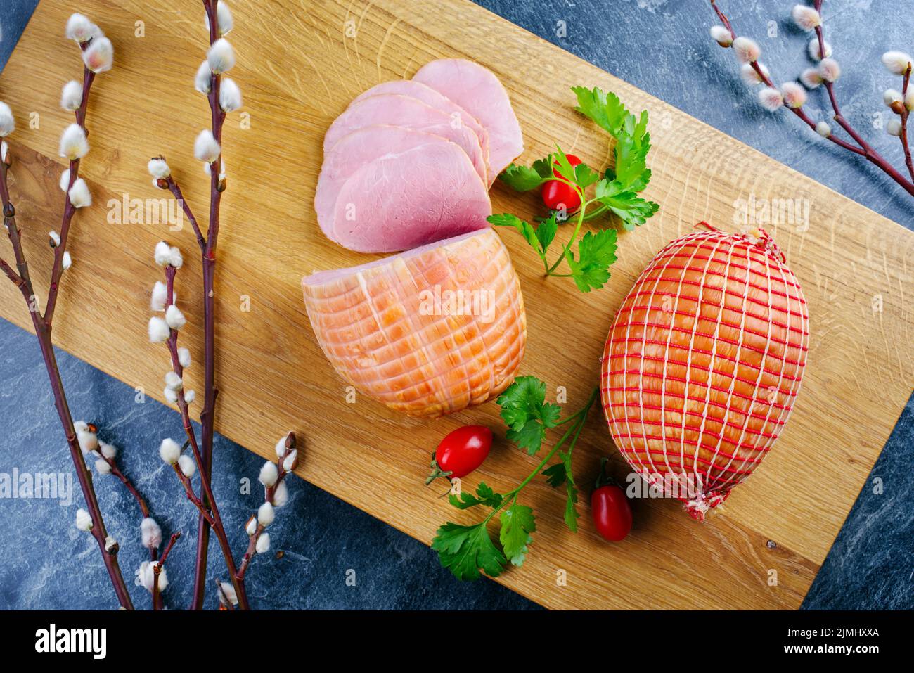 Traditional German boiled Easter ham with tomatoes and eggs offered as top view on modern design