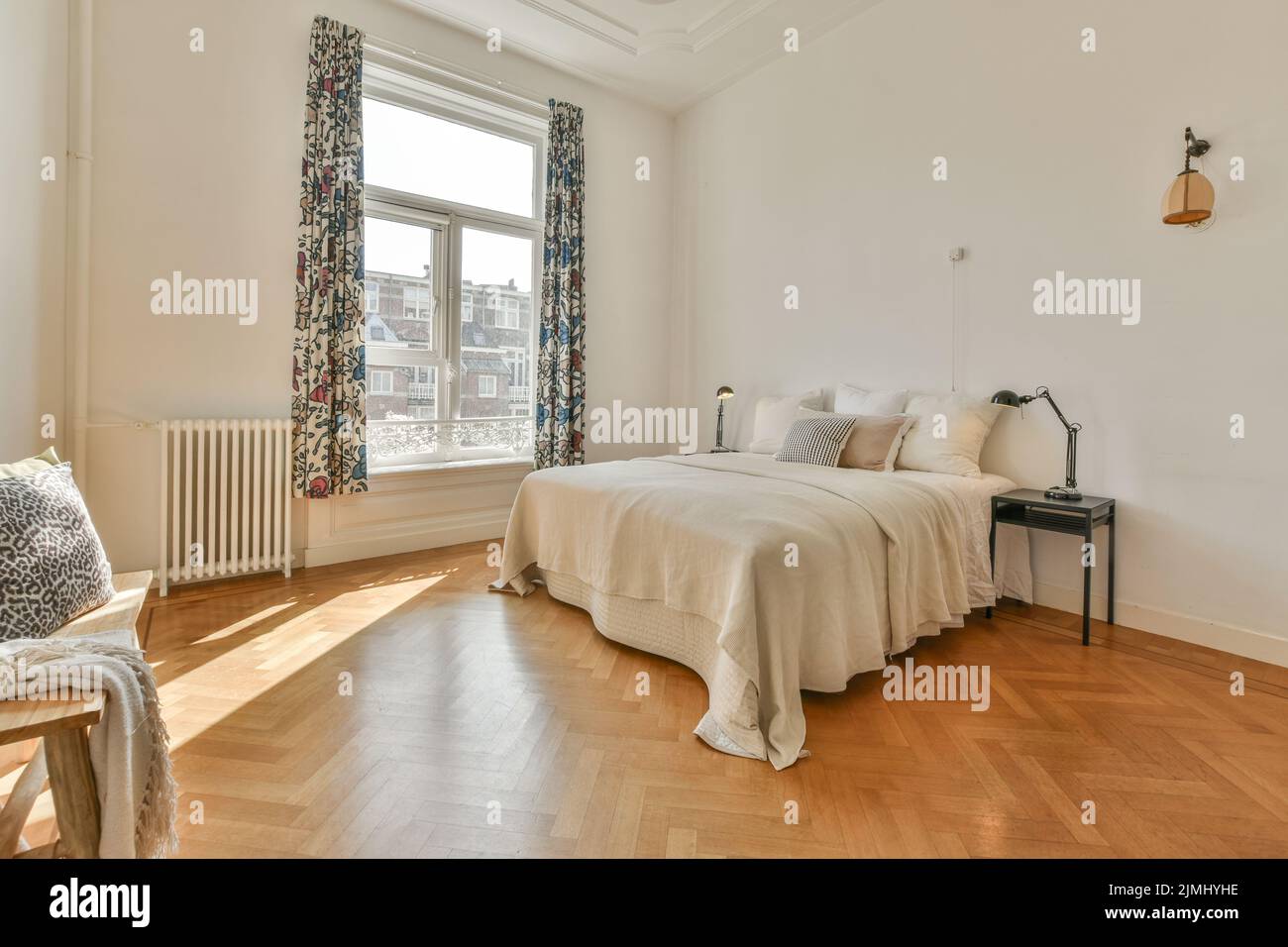 Comfortable bed with pillows and warm blanket located near window in