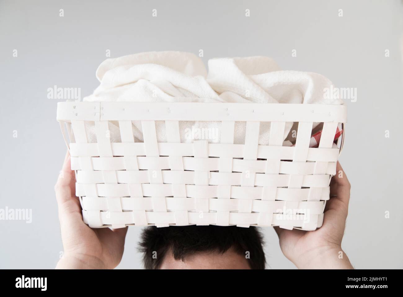 Front view person holding laundry basket head Stock Photo