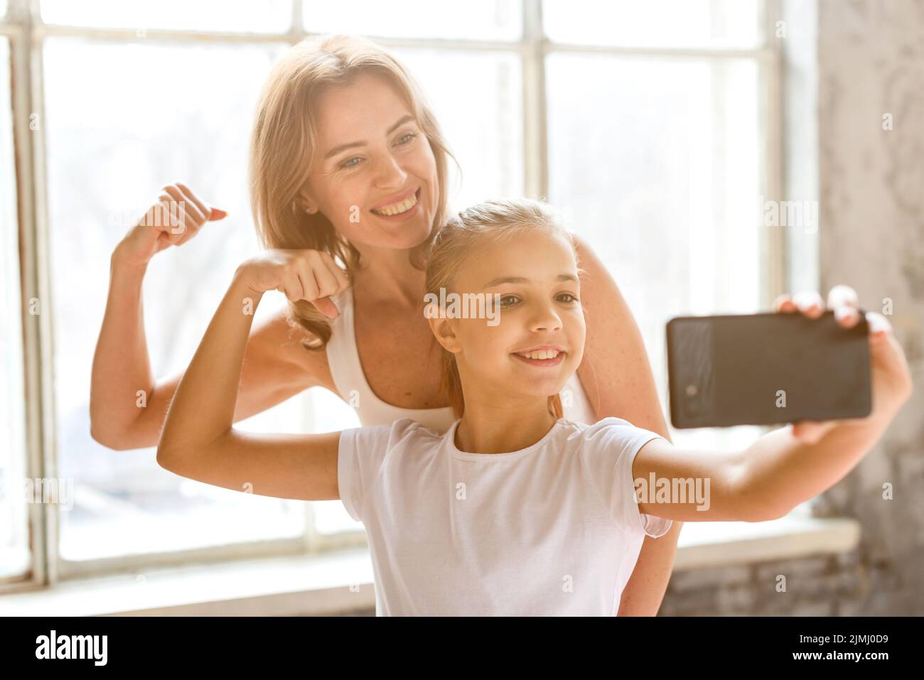Mother daughter taking selfie flexing arm muscles Stock Photo Alamy