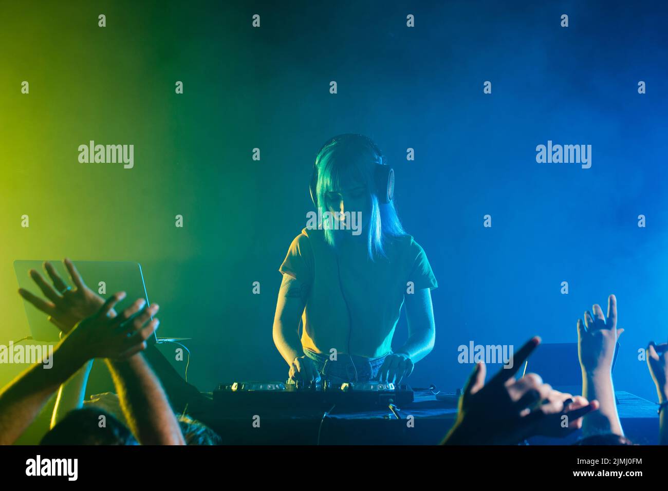 Clubbing with female dj mixing crowd Stock Photo