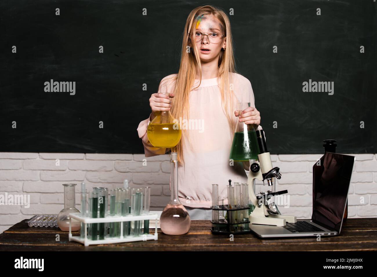 Funny little school child doing experiments in the laboratory
