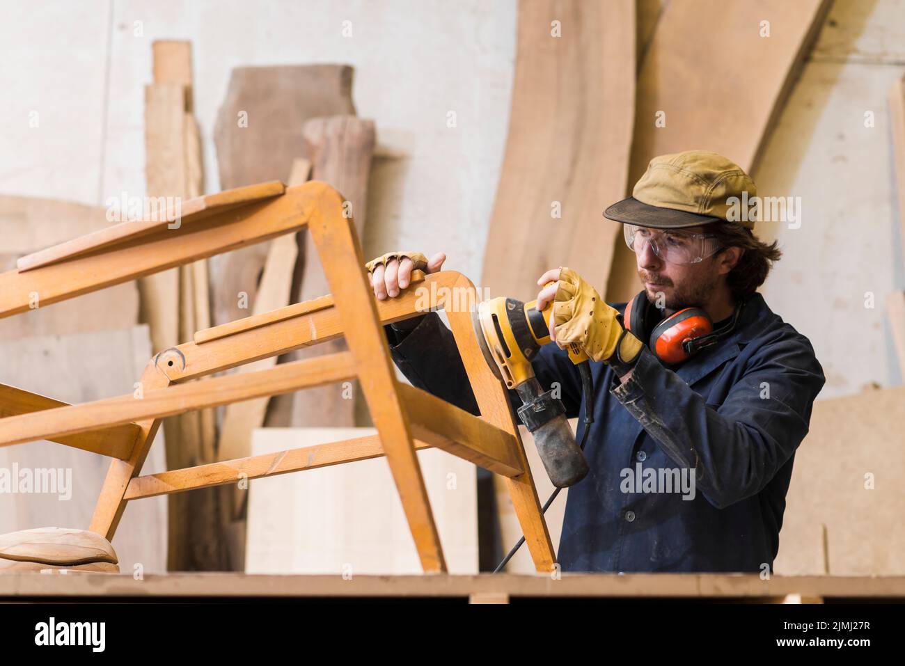 Male carpenter sanding wood with orbital sander Stock Photo
