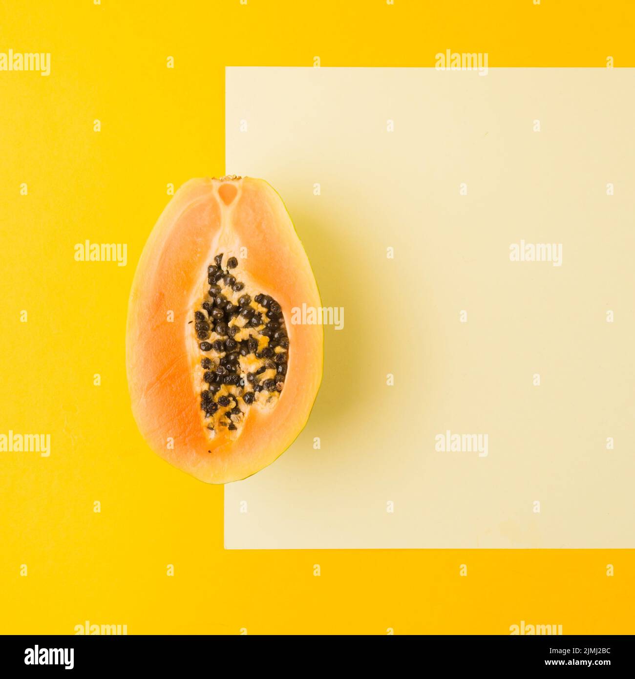 Ripe halved papaya blank paper against yellow backdrop Stock Photo Alamy