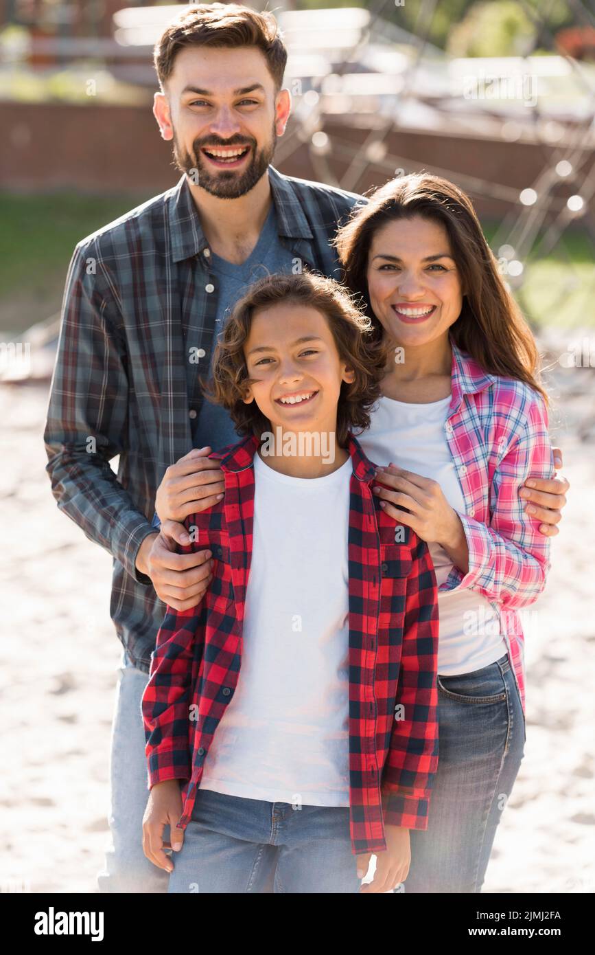 Front view parents with child posing while outdoors Stock Photo