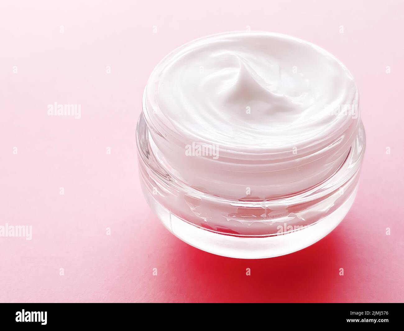 Face cream jar on pink background, beauty, skincare and cosmetic