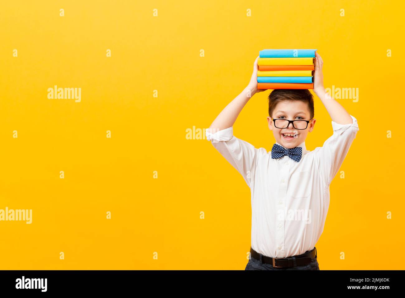Copy space boy holding stack books Stock Photo