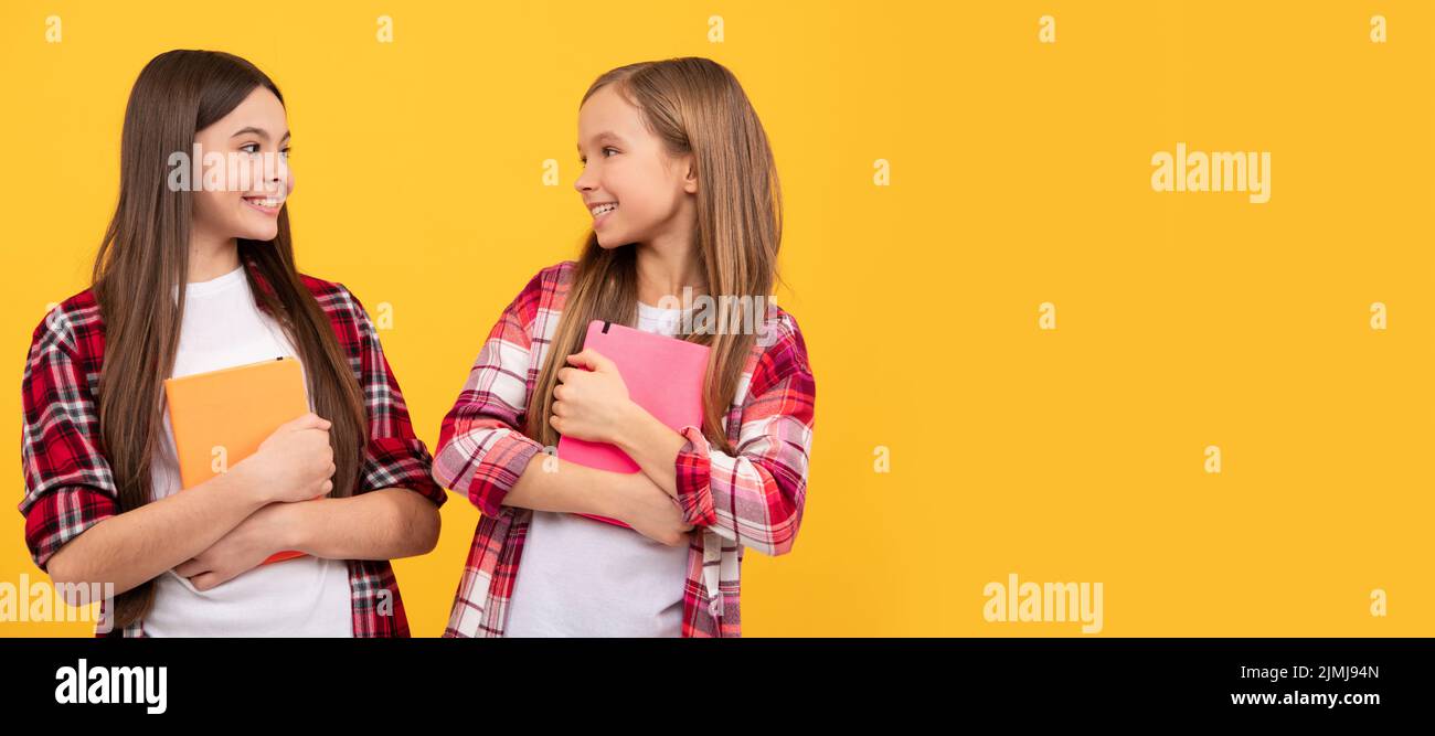School girls friends. happy teen girls in casual checkered shirt with notebooks, sisterhood. Horizontal isolated poster of school girl student. Banner Stock Photo