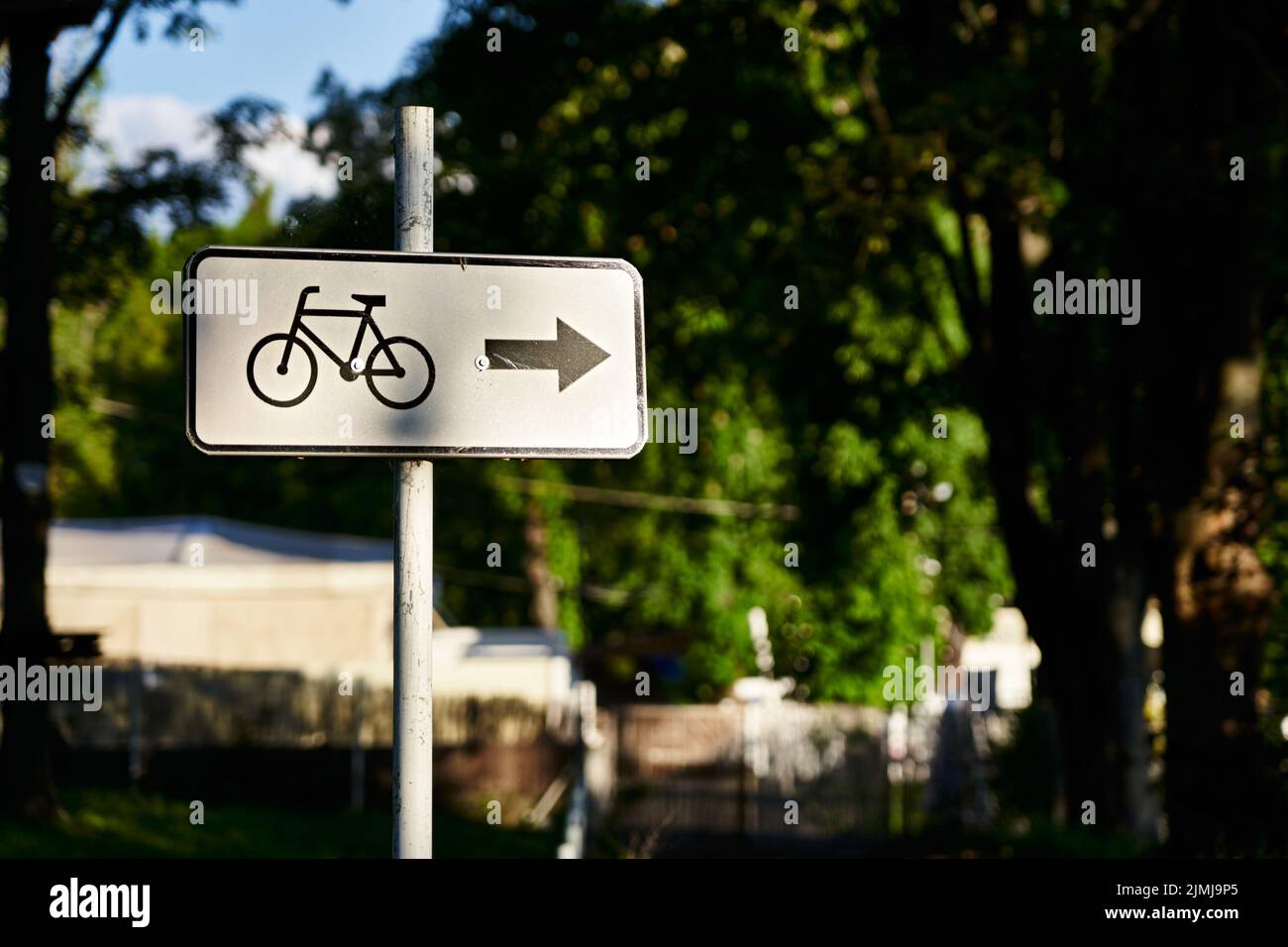 A white bicycle direction sign pointing to the right Stock Photo - Alamy
