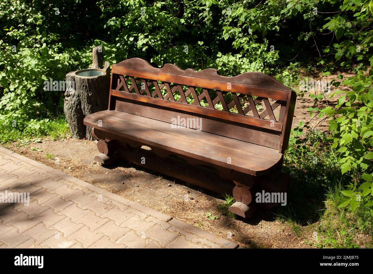 Park tree stump bench with stump urn Stock Photo - Alamy