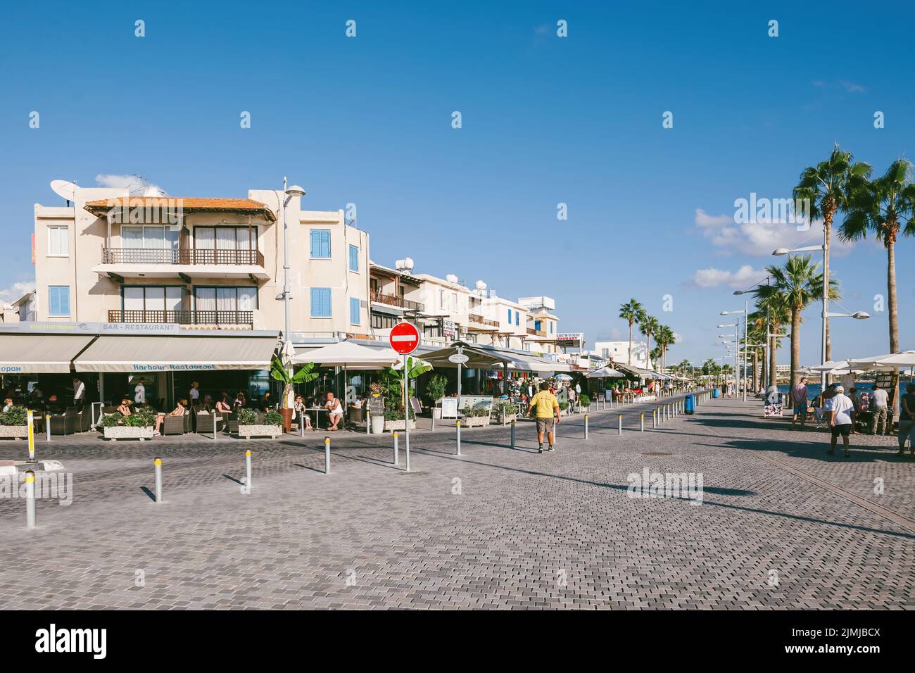 Paphos, Cyprus - Oct 29, 2014: Poseidonos Ave, Paphos, Cyprus with people tourists and locals near the Harbour restaurants, souvenir shop tall palm trees Stock Photo