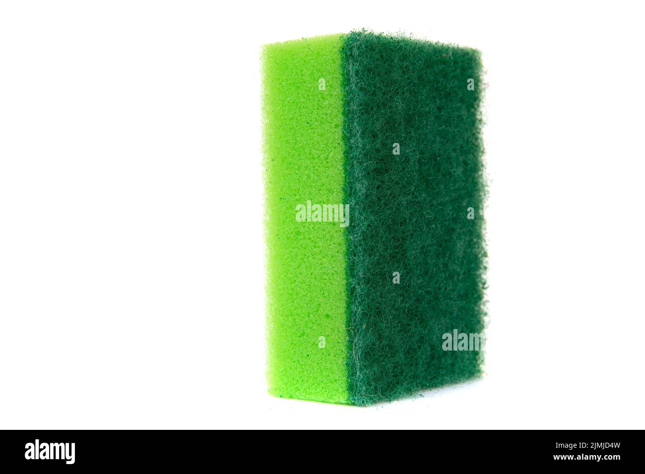 Green dishwashing sponge stands upright on a white isolated background, close-up, Stock Photo