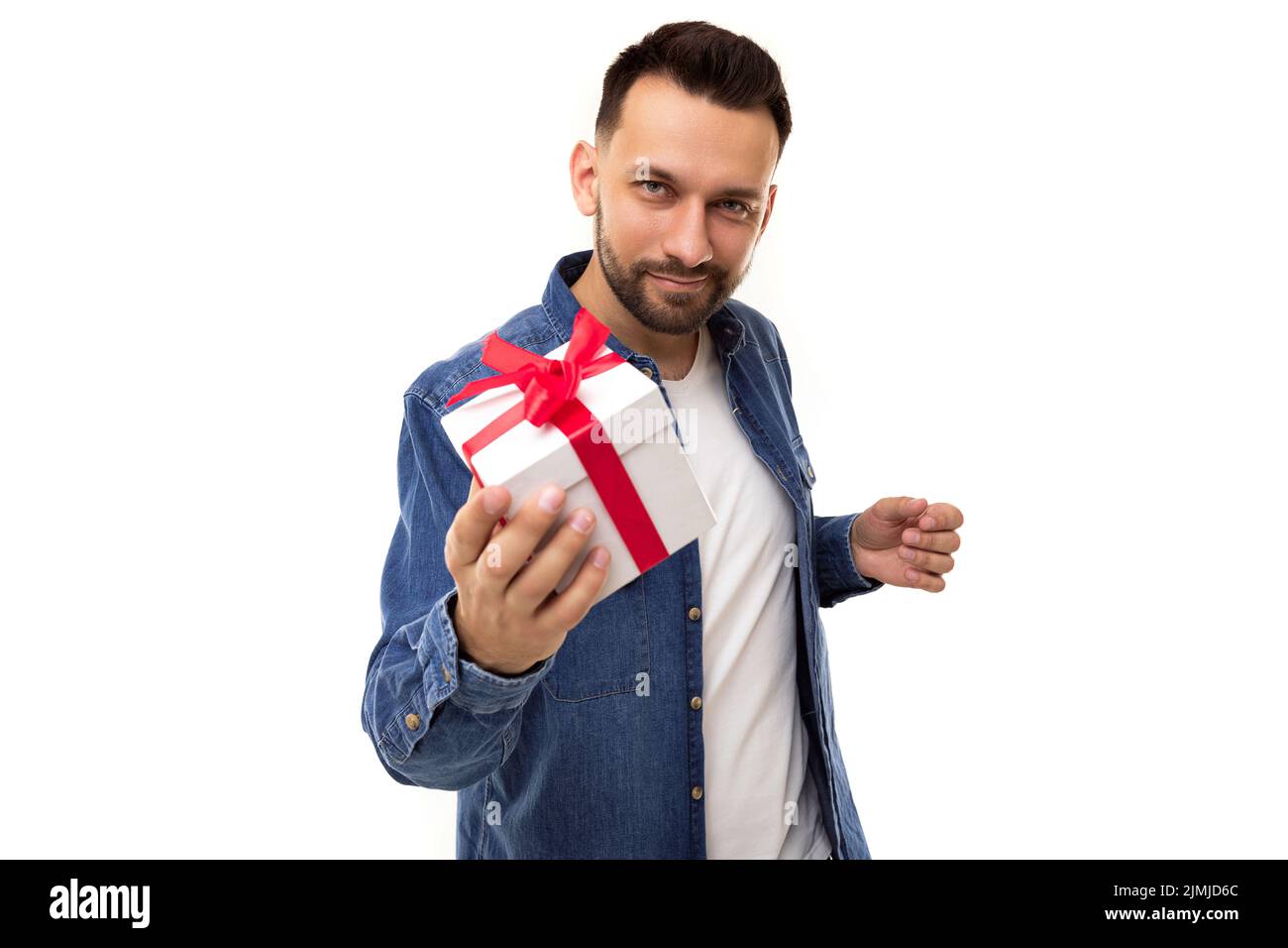 Young man on white background with white gift box with red bow Stock Photo