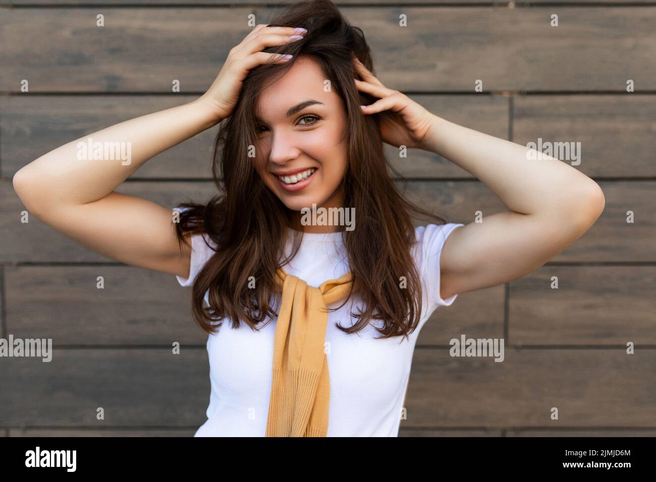 Close-up photo of pretty attractive beautiful smiling happy positive charming young brunette young woman wearing stylish clothes Stock Photo