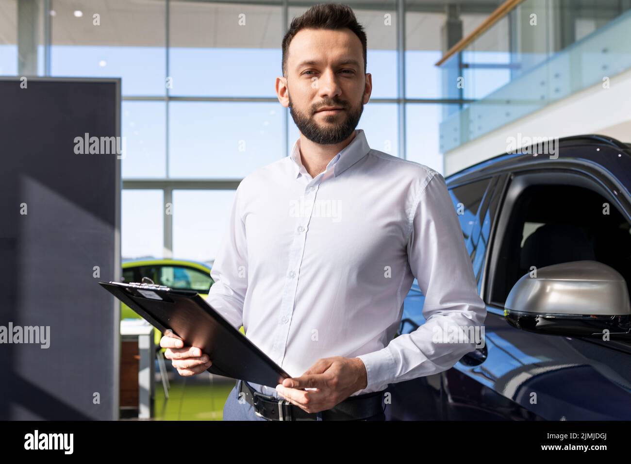 Manager in a car dealership prepares papers for buying a new car Stock Photo