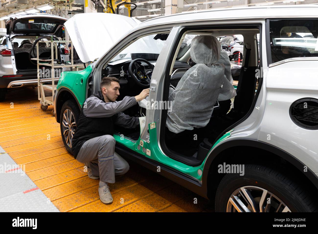 Minsk, Belarus - Dec 15, 2021: Car bodies are on assembly line. Factory for production of cars. Modern automotive industry. Elec Stock Photo