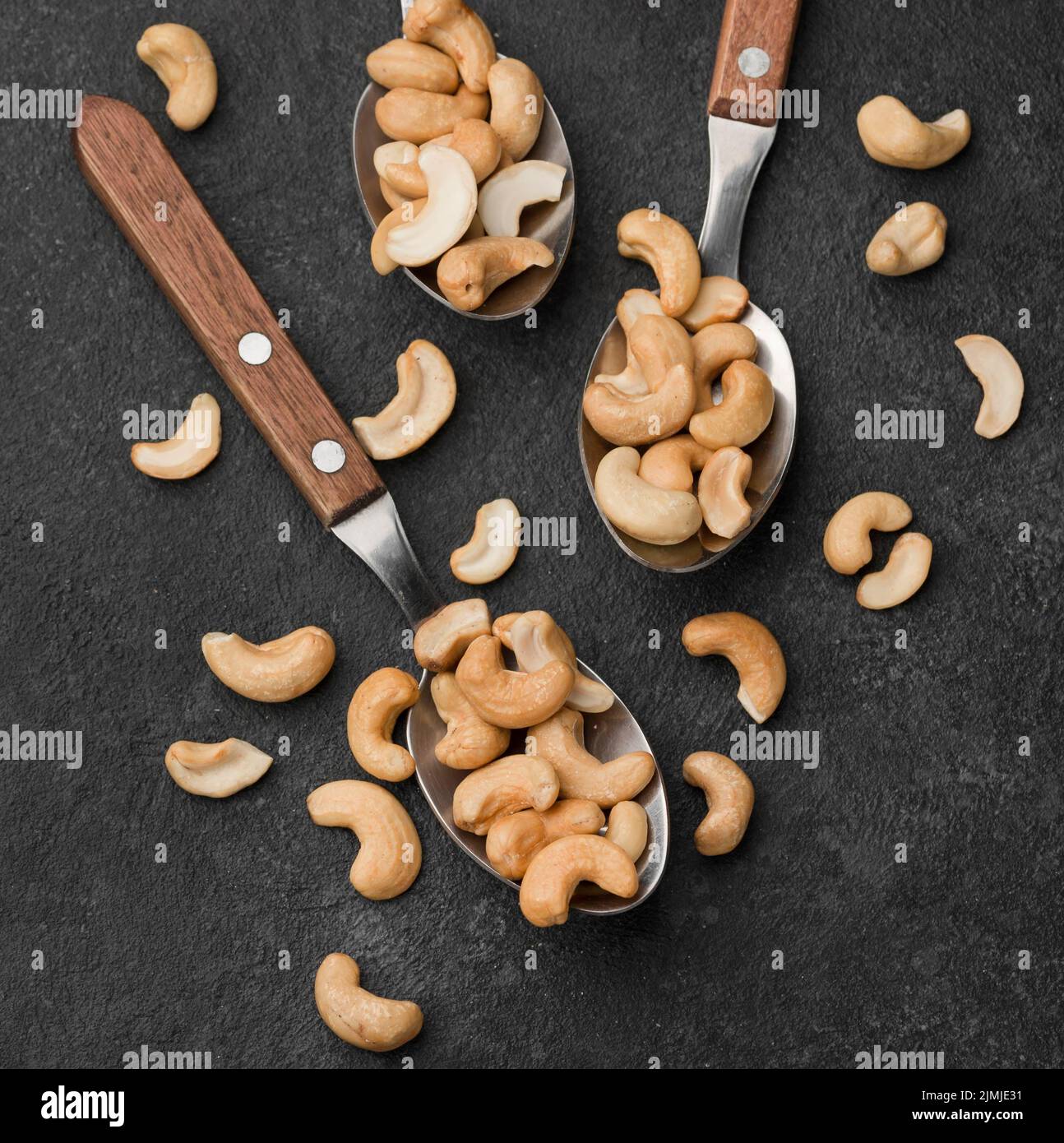 Close up spoons filled with healthy raw cashew nuts Stock Photo