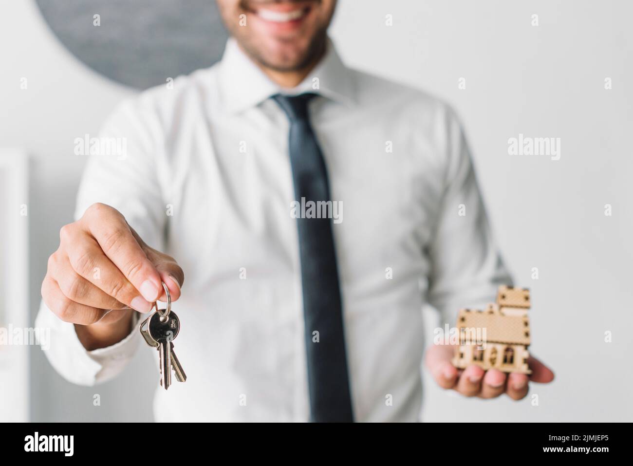 Crop real estate agent with keys house Stock Photo