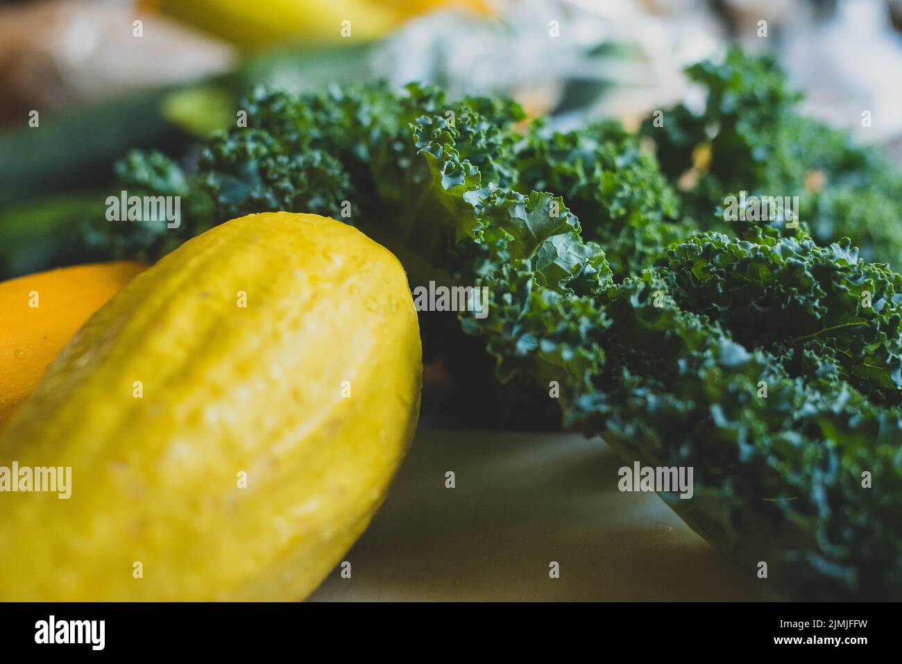 Squash and collard greens on a cutting board. - Stock Image