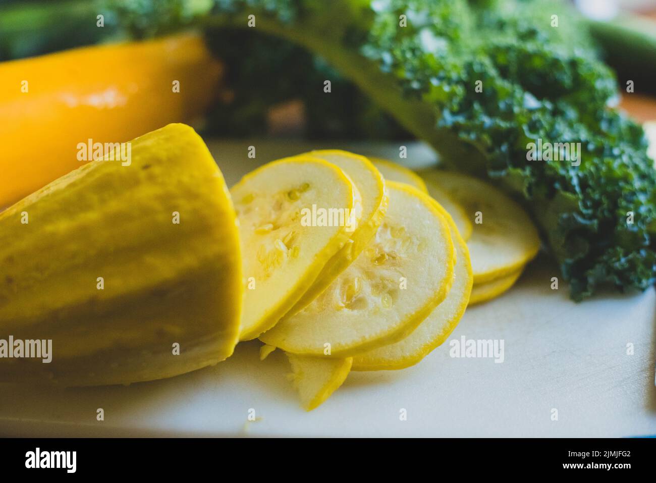 Squash and collard greens on a cutting board. - Stock Image