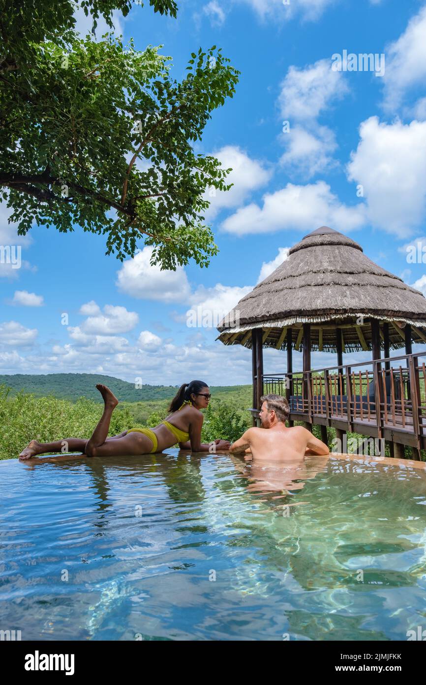 Couple men and woman by the pool on a luxury safary,South Africa Kwazulu natal, luxury safari lodge in the bush Stock Photo