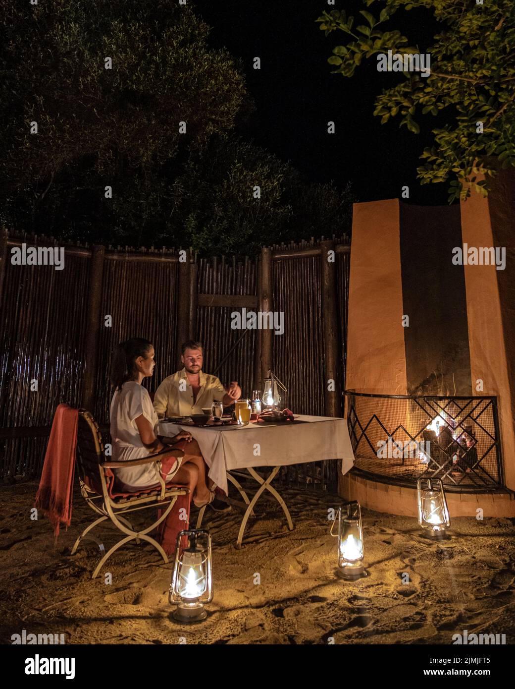 Couple man and woman having dinner in the bush at night, South Africa Kwazulu natal, luxury safari lodge in the bush Stock Photo