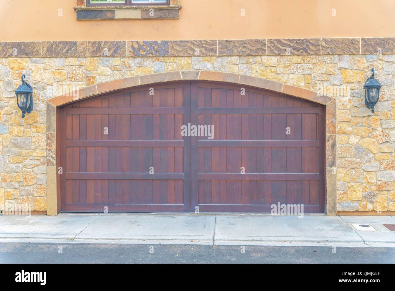 Double wooden garage doors with arched entrance design at Carlsbad, San