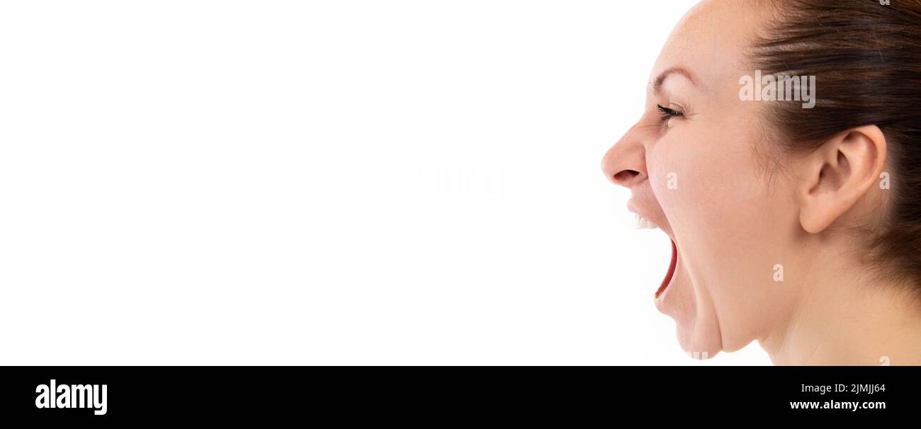 A woman emotionally screams with her mouth wide open, profile picture on a white background Stock Photo