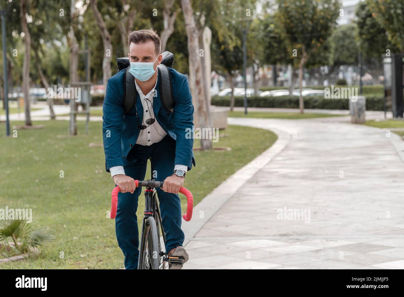 Man riding bike while wearing medical mask Stock Photo - Alamy
