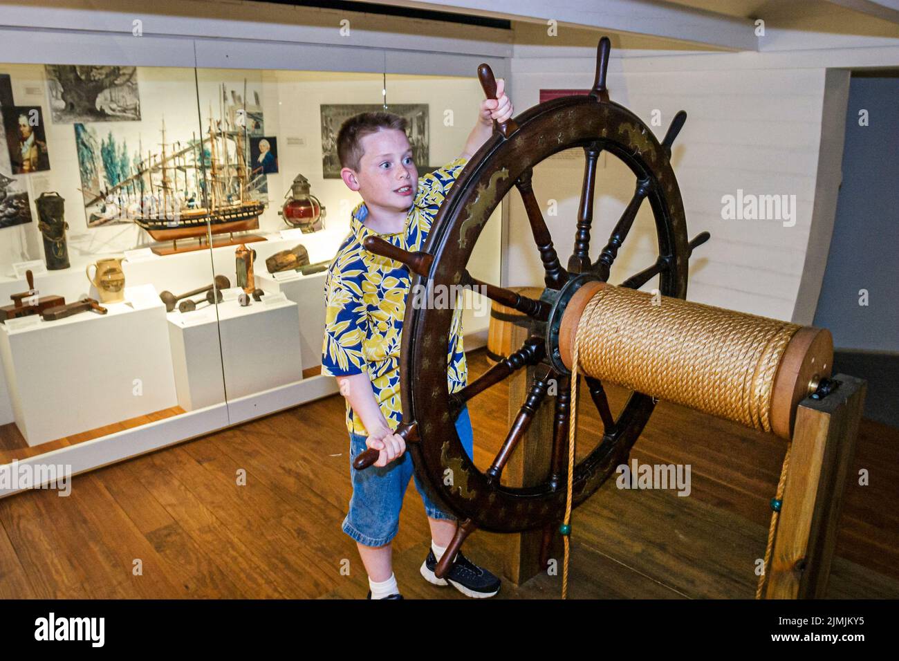 Virginia Newport News Mariners' Museum and Park,inside interior history exhibit collection looking,boy operating ship's steering wheel helm helmsman Stock Photo