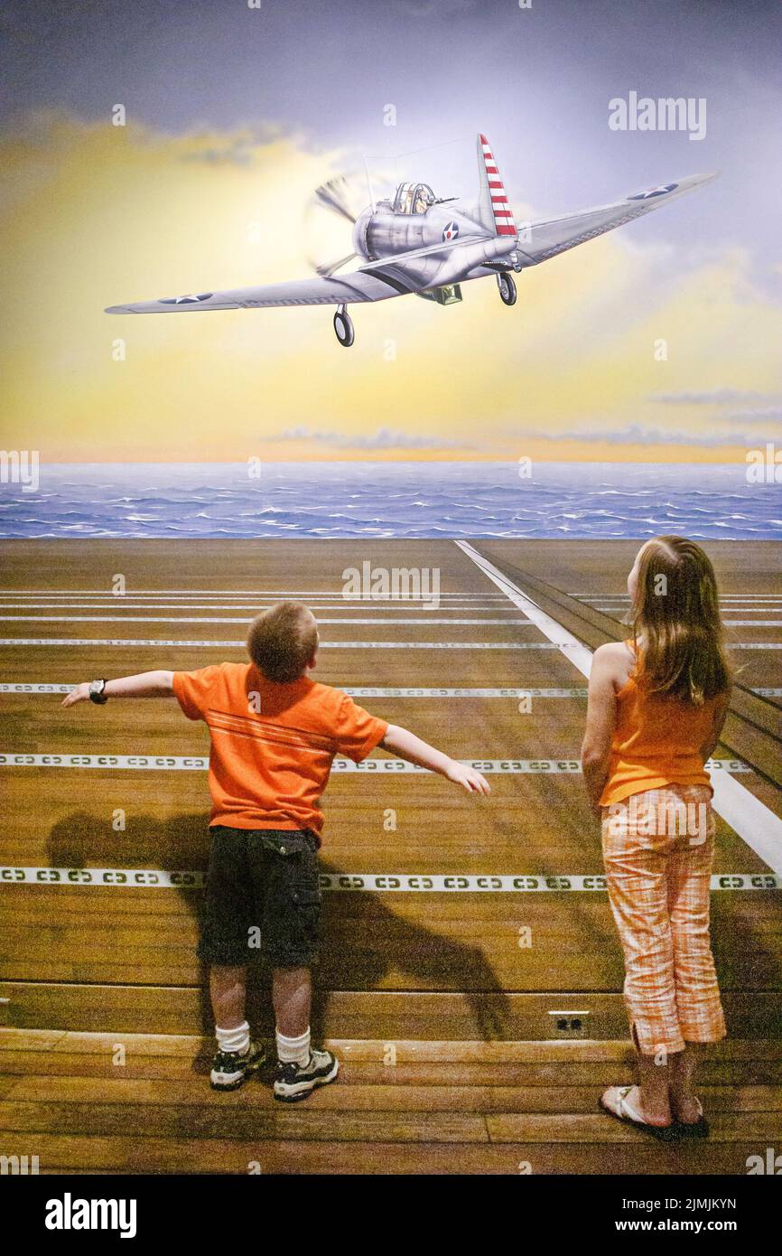 Virginia Newport News Mariners' Museum and Park,inside history exhibit looking,boy girl brother sister mural art artwork airplane aircraft carrier Stock Photo