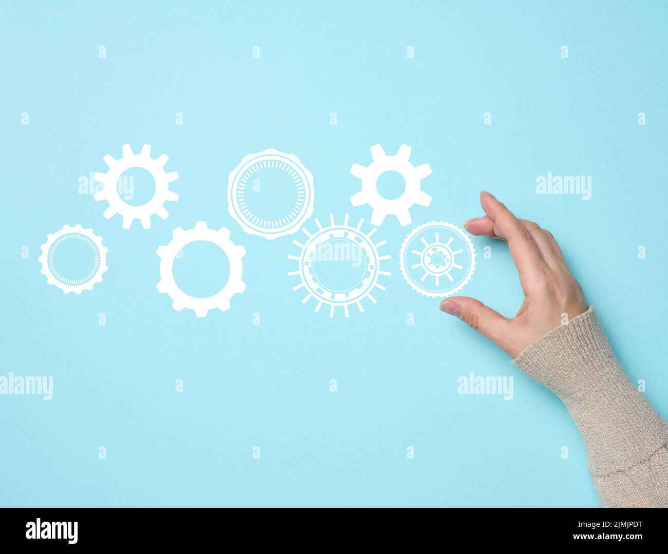 Gear wheels and female hand on a blue background. Business structure precise work concept, team unification Stock Photo