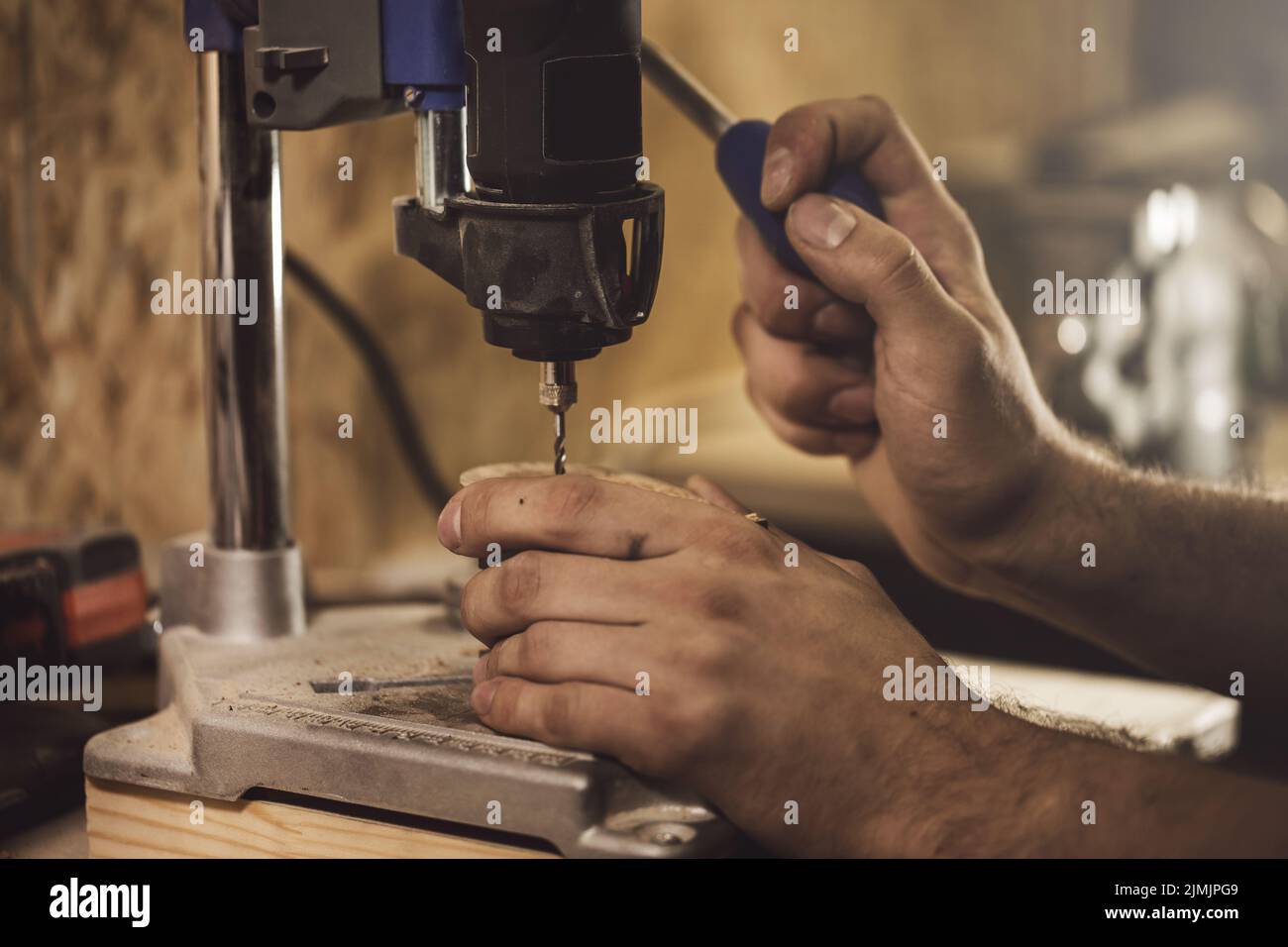 Carpenter is working on the drill machine Stock Photo