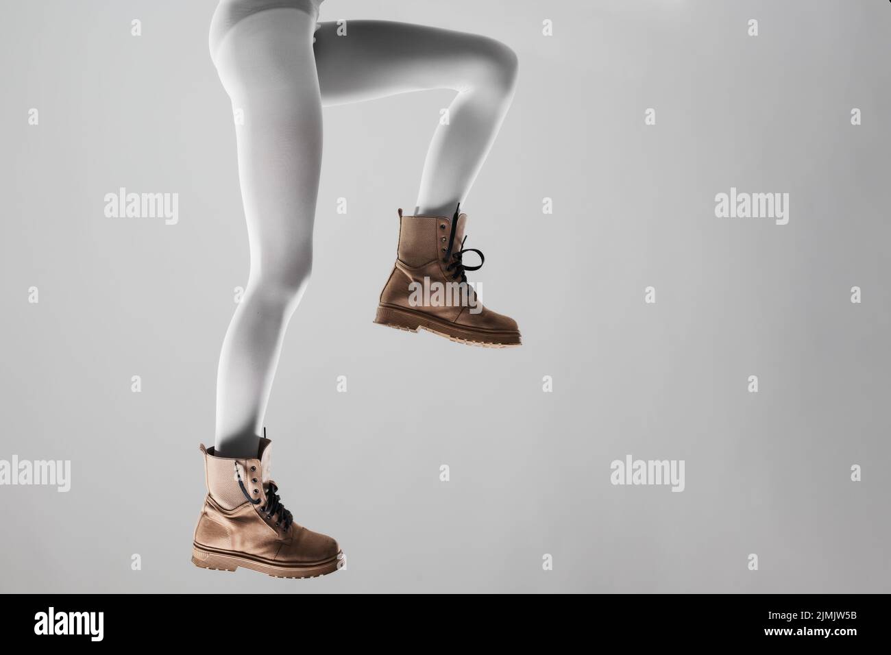 Sexy female legs with white leggings and waterproof boots. Stock Photo